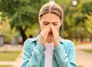 woman rubbing her face due to allergies
